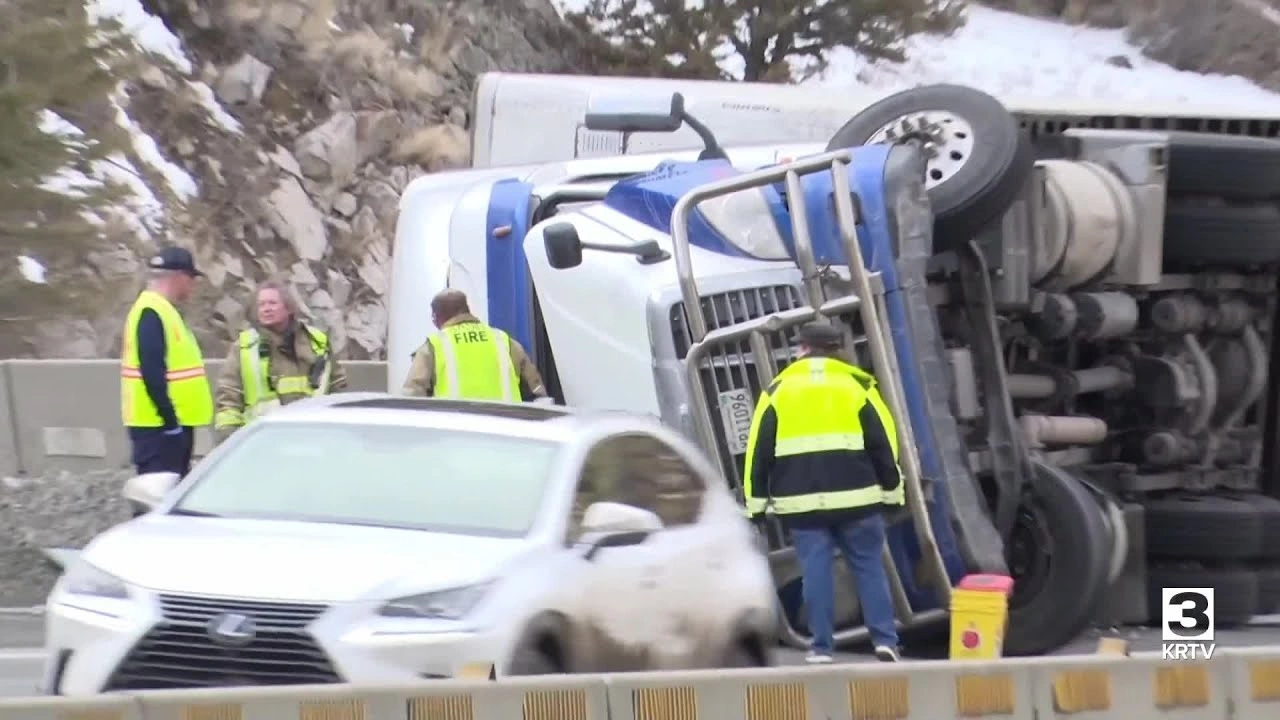 Commercial vehicle accident scene with damaged trucks and debris on the road.
